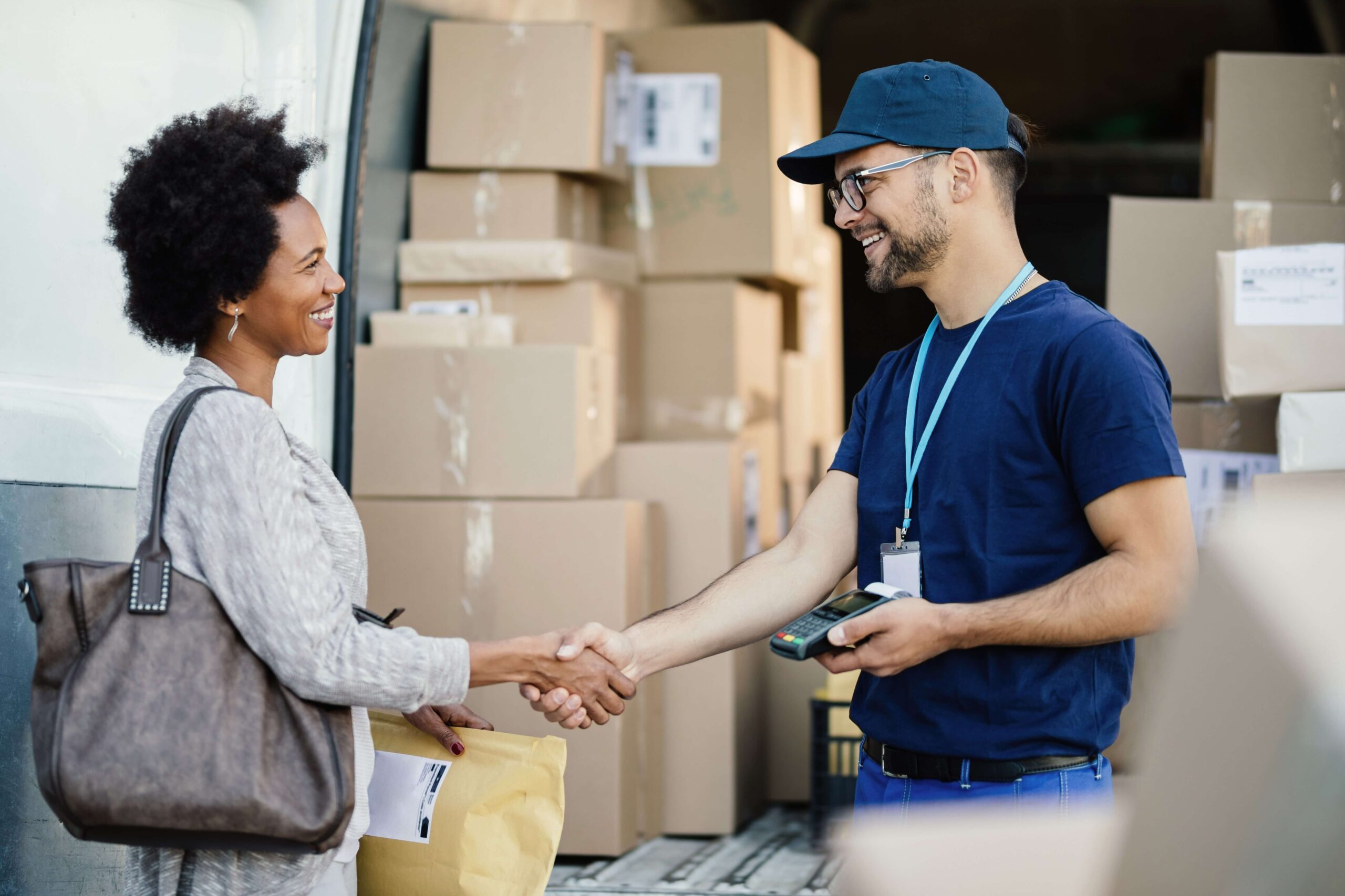 happy-courier-handshaking-with-african-american-woman-while-delivering-her-package happy-courier-handshaking-with-african-american-woman-while-delivering-her-package